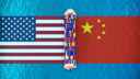 Freight ship sailing on ocean, passing between US and Chinese flags