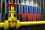 A Russian flag crudely painted on stacks of oil barrels in front of a yellow oil pipeline