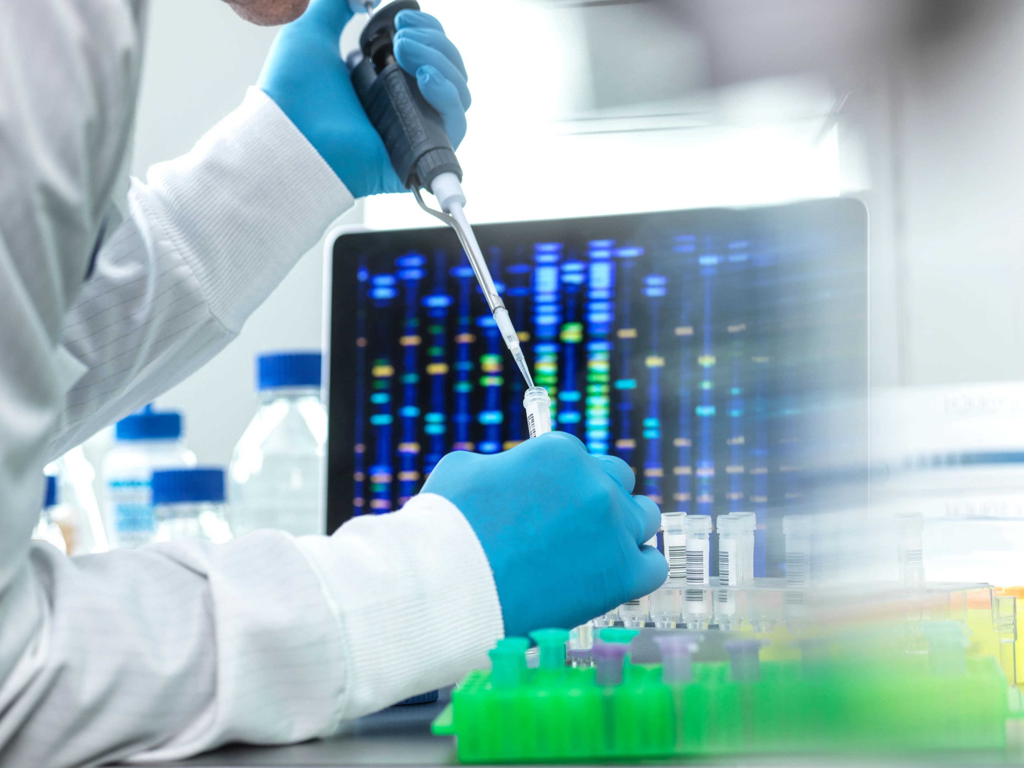 Scientist experimenting in lab wearing protective gloves and handling equipment
