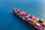 Freight liner crossing the ocean, carrying dozens of multi-coloured containers