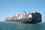 Container ship on calm sea against blue sky