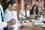 Business meeting between a woman and a man, with both looking at a laptop while sat at a table